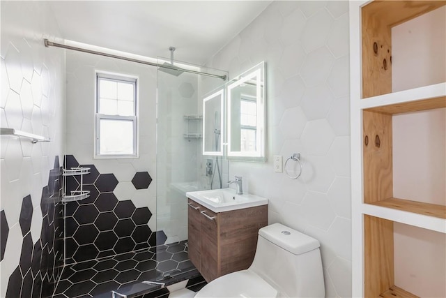 full bathroom featuring toilet, a shower stall, tile walls, and vanity