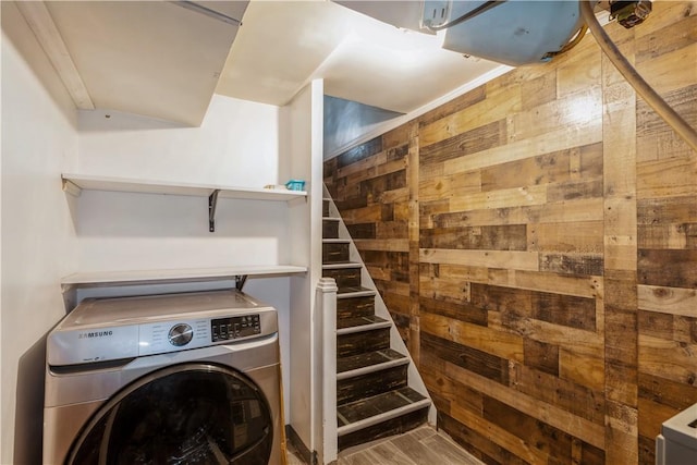 laundry area featuring laundry area, wood finished floors, washer / dryer, and wooden walls