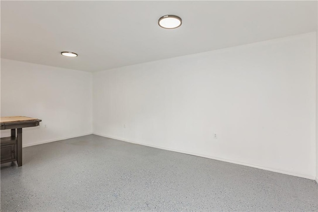 empty room with baseboards and speckled floor