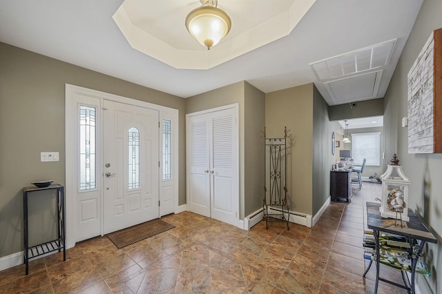 entrance foyer with a tray ceiling, baseboards, and a baseboard radiator