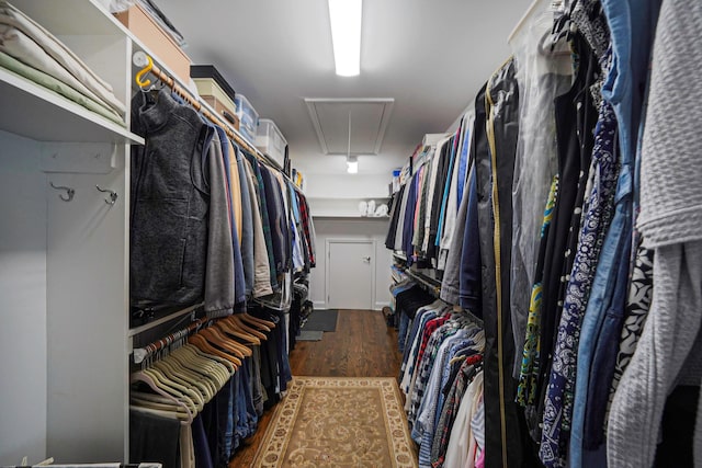 walk in closet featuring attic access and dark wood finished floors