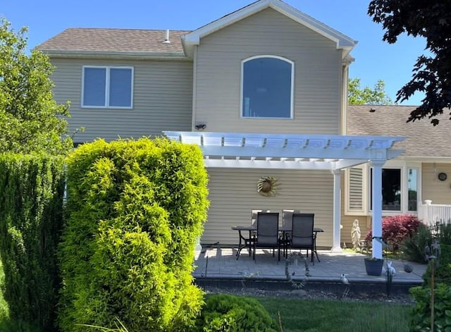 rear view of house with a shingled roof and a pergola