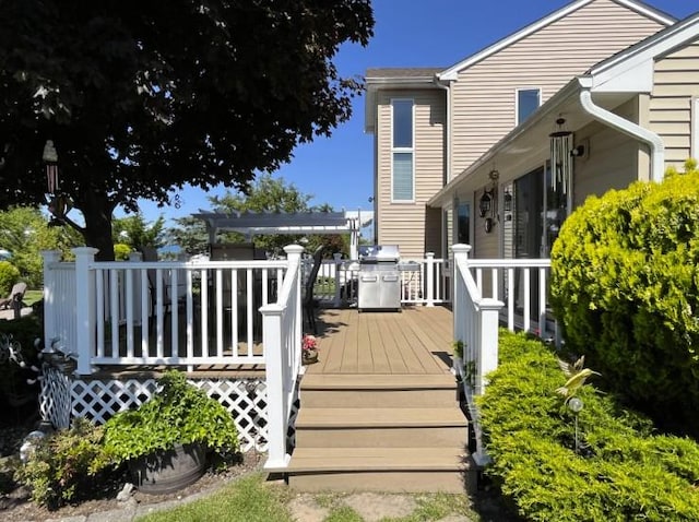 deck featuring grilling area and a pergola