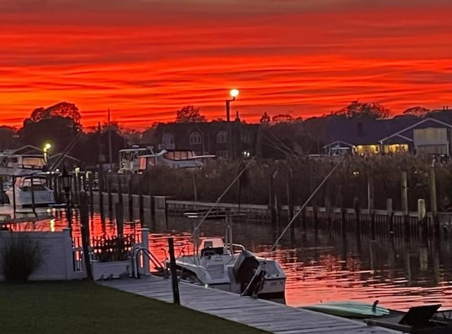 view of dock featuring a water view and a yard