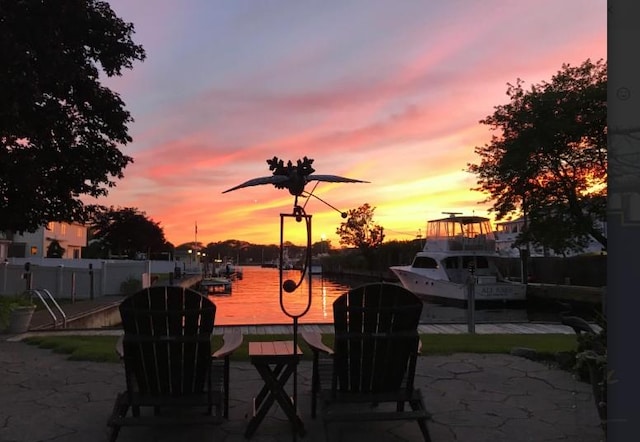 patio terrace at dusk featuring a water view