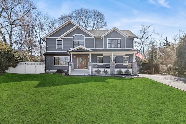 view of front of property featuring covered porch, a front lawn, fence, and a gate