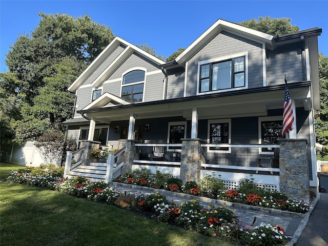 craftsman house with a porch and fence