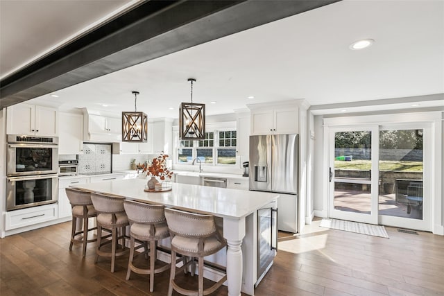 kitchen with white cabinetry, appliances with stainless steel finishes, light countertops, and a center island