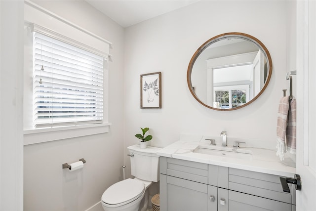 half bath with toilet, plenty of natural light, and vanity