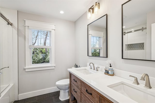 bathroom with a healthy amount of sunlight, a sink, and baseboards