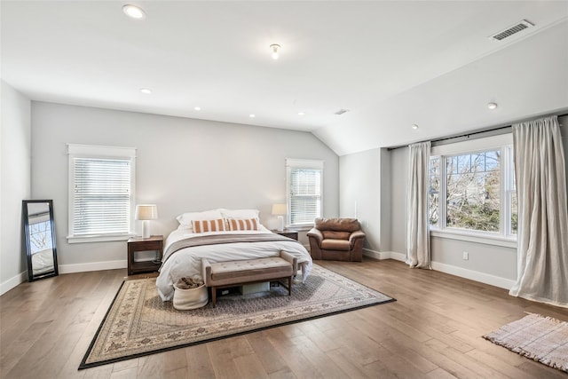 bedroom featuring multiple windows, wood finished floors, visible vents, and baseboards