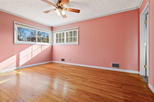 unfurnished room with light wood finished floors, baseboards, visible vents, and ornamental molding