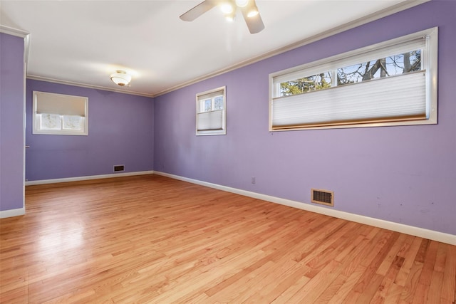 spare room with plenty of natural light, visible vents, and crown molding