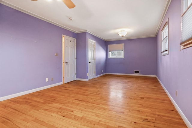 empty room with visible vents, light wood-style floors, ornamental molding, ceiling fan, and baseboards