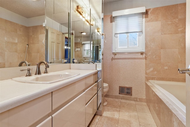 bathroom featuring a relaxing tiled tub, visible vents, toilet, tile patterned flooring, and vanity