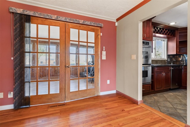 kitchen featuring double oven, visible vents, dishwasher, and light wood finished floors