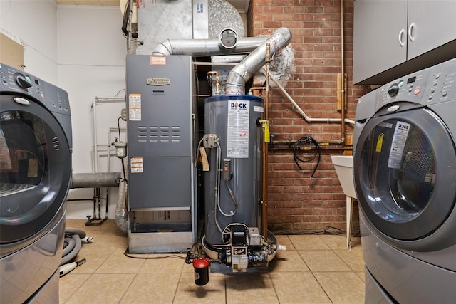 laundry room with cabinet space, brick wall, tile patterned floors, heating unit, and water heater