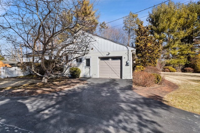 garage featuring driveway and fence