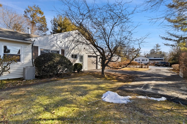 exterior space featuring a garage, driveway, and central air condition unit