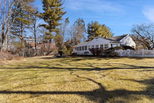 view of side of home with a gate, a yard, and fence