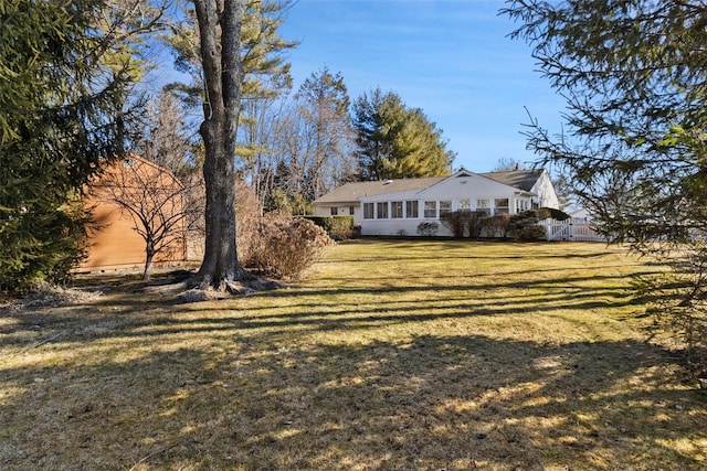 exterior space with a sunroom and a lawn