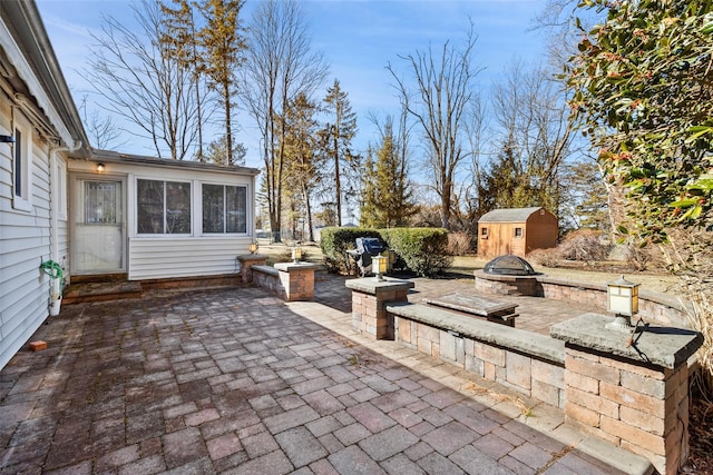 view of patio / terrace with an outbuilding, a fire pit, and a storage shed