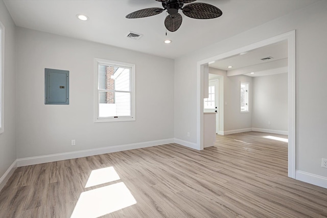 unfurnished room featuring visible vents, light wood-style flooring, plenty of natural light, and electric panel