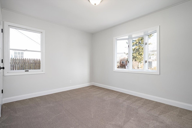 carpeted spare room featuring baseboards