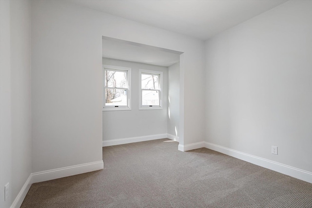 unfurnished room featuring carpet flooring and baseboards