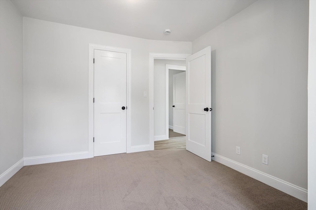 unfurnished bedroom with baseboards and light colored carpet