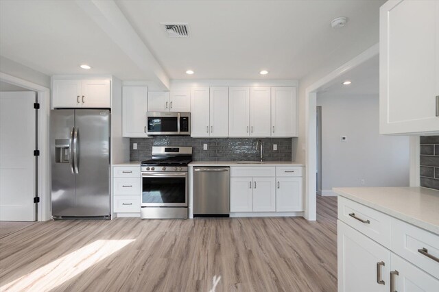 kitchen with white cabinetry, light wood-style flooring, visible vents, and appliances with stainless steel finishes