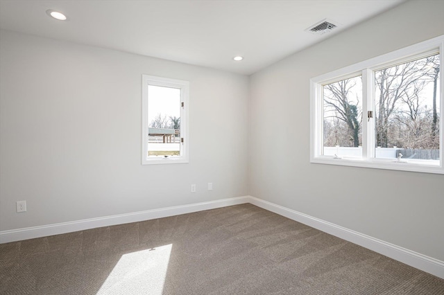 empty room with baseboards, visible vents, and a wealth of natural light