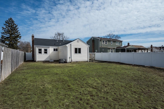 back of property featuring cooling unit, a fenced backyard, and a lawn