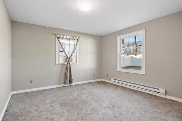 carpeted empty room with a baseboard radiator and baseboards