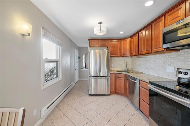 kitchen featuring a baseboard radiator, a sink, appliances with stainless steel finishes, backsplash, and brown cabinets