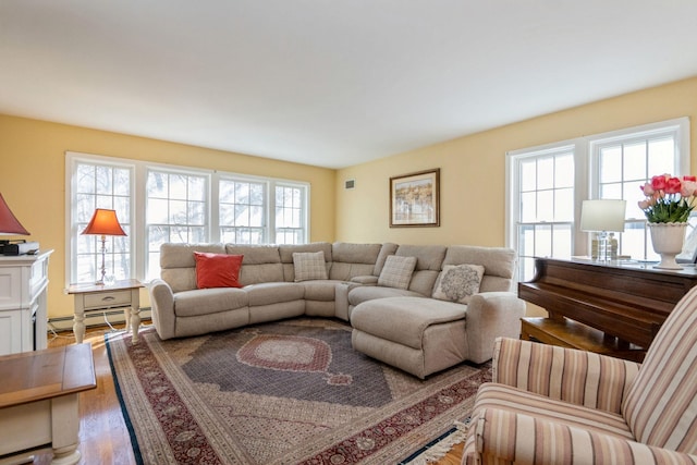 living area with a baseboard heating unit and wood finished floors