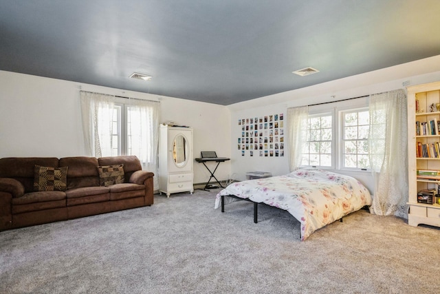 carpeted bedroom featuring visible vents