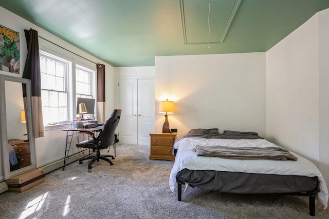 carpeted bedroom with a closet and attic access