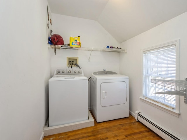 laundry room with laundry area, wood finished floors, a baseboard radiator, and washing machine and dryer