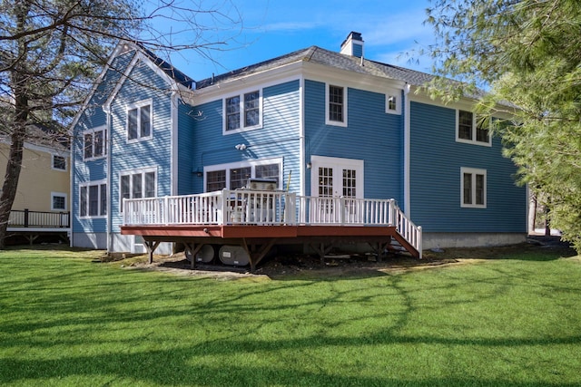 back of house featuring a yard, a chimney, a deck, and french doors