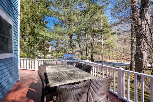 deck with outdoor dining area and a grill