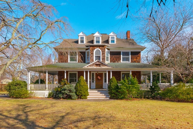 view of front facade featuring covered porch and a front lawn