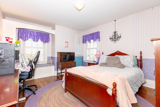 bedroom with wallpapered walls, multiple windows, and wood finished floors