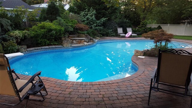 view of swimming pool with a fenced in pool, fence, and a patio