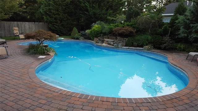 view of swimming pool featuring a patio, fence, and a fenced in pool