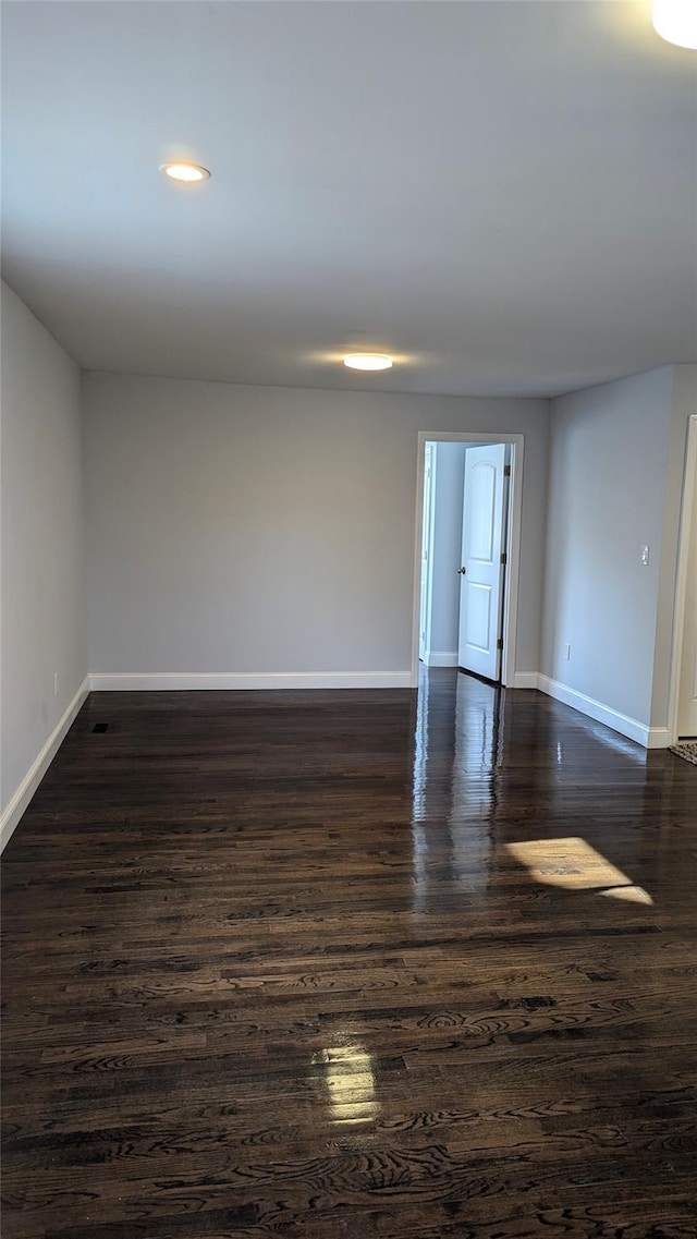 unfurnished room with dark wood-style floors and baseboards