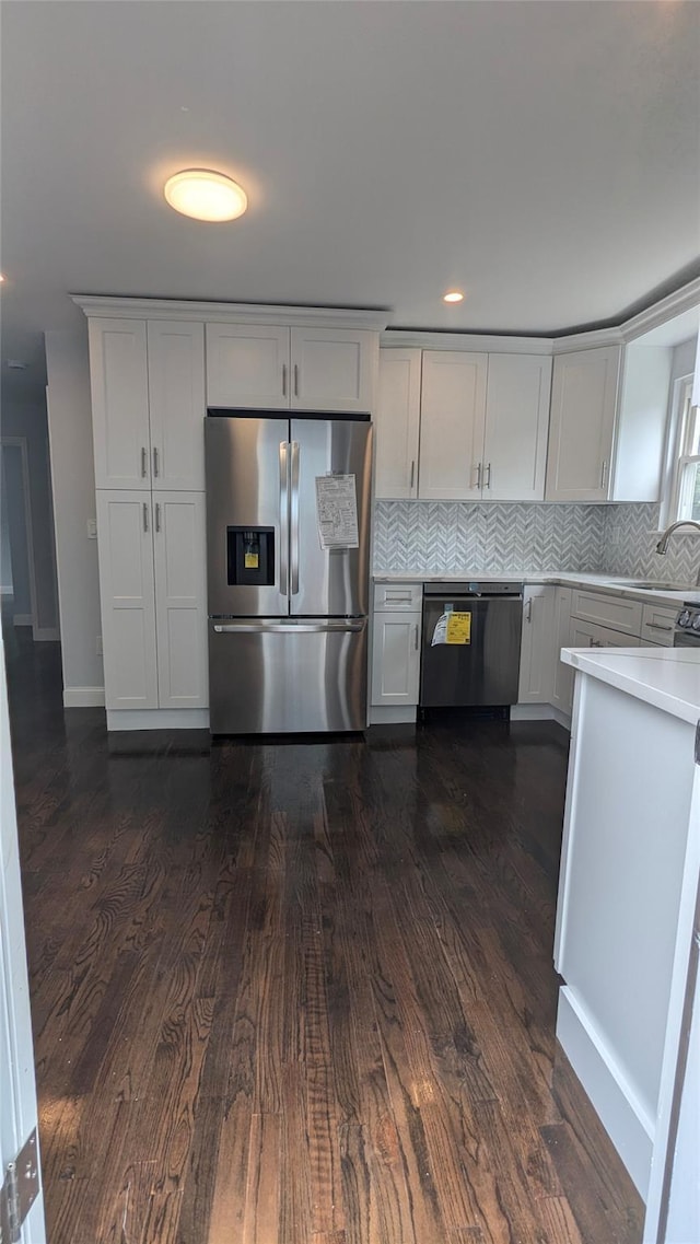 kitchen featuring stainless steel refrigerator with ice dispenser, light countertops, backsplash, white cabinets, and dishwasher