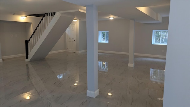 basement with marble finish floor, baseboards, and stairs