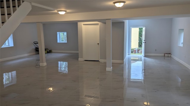 basement featuring marble finish floor, stairway, and baseboards