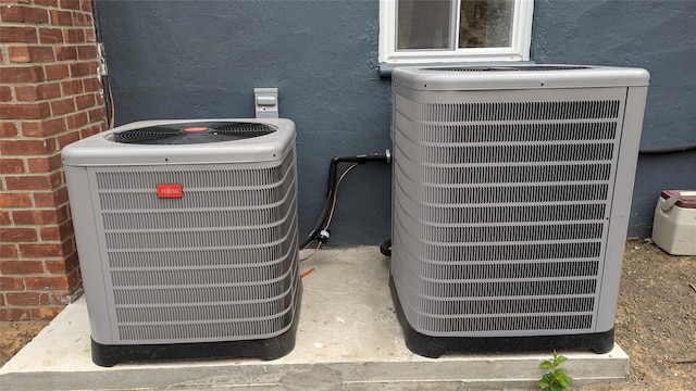 details featuring central AC unit and brick siding